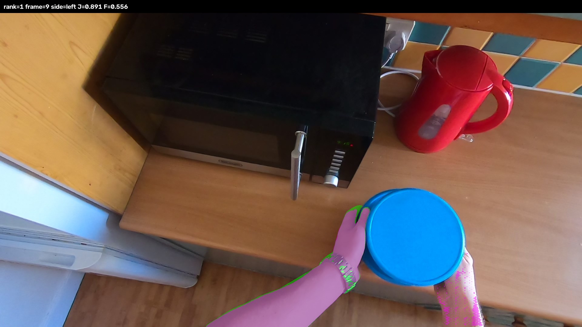 Egocentric kitchen frame showing candidate hand masks while holding a blue bowl